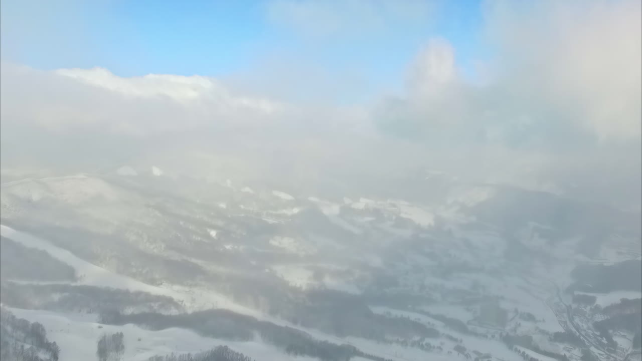vista panorámica de un valle nevado bajo nubes gruesas