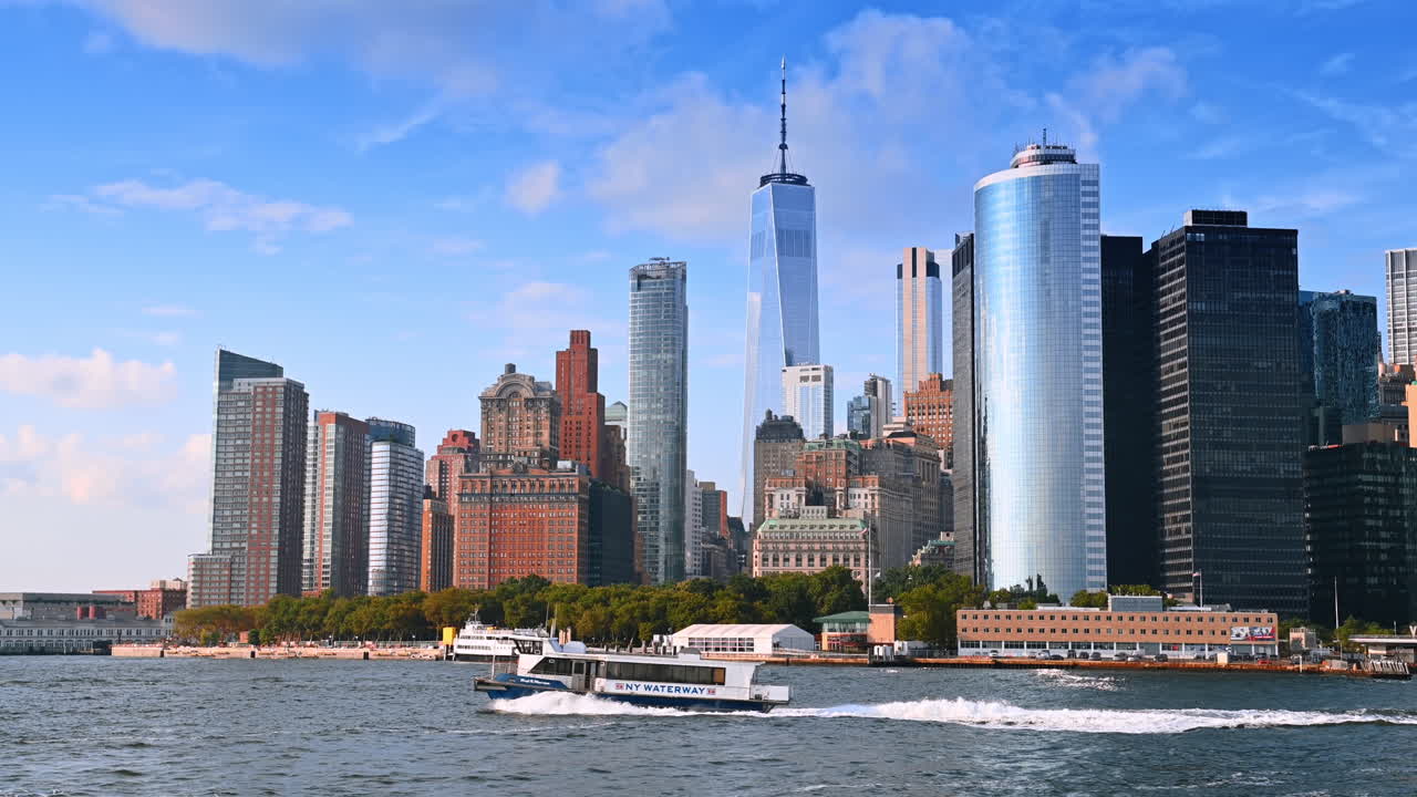 New York, USA, 1 agosto 2025: un battello si muove velocemente lungo il litorale. Grattacieli di New York, USA, sullo sfondo.