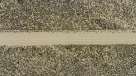 drone flies in bird's eye view over a road where no car drives in cederberg wilderness area in south africa