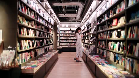 woman browsing books in a modern bookstore