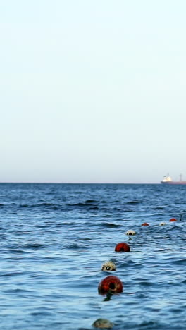 floating buoy on blue sea. lots of empty red mooring buoys floating on water
