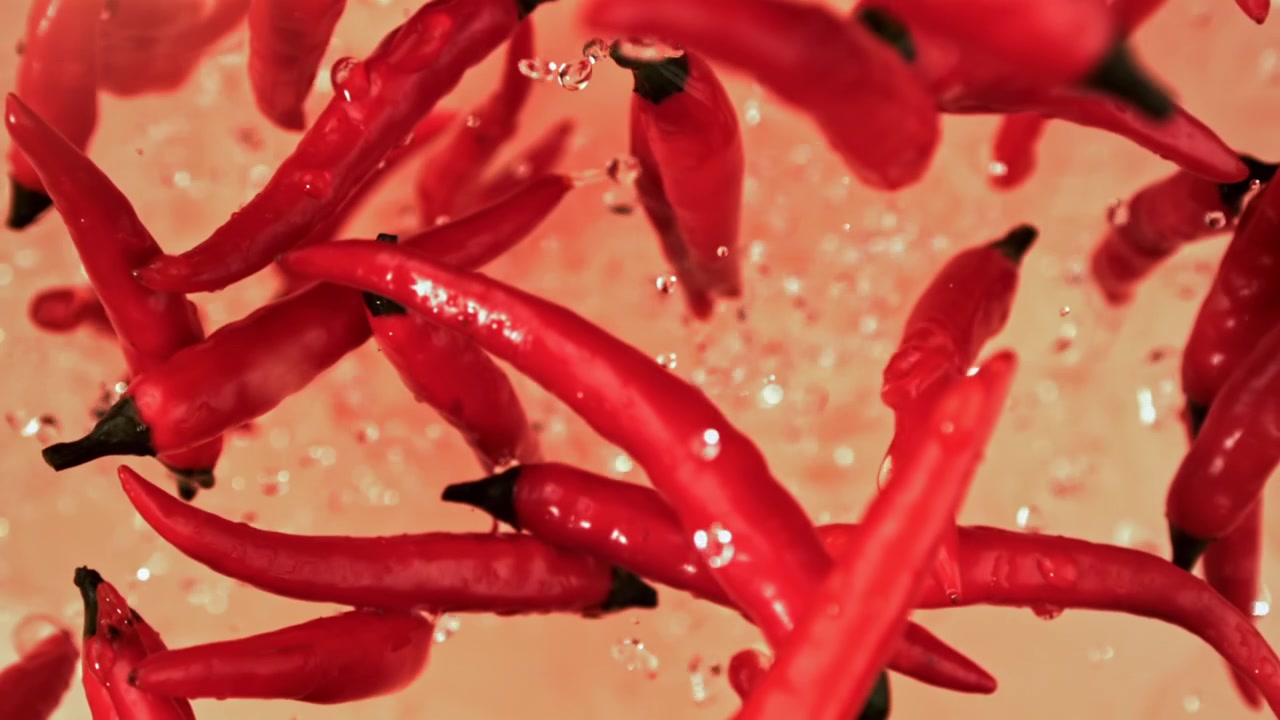 Vibrant Red Chili Peppers Floating in Water with Bubbles