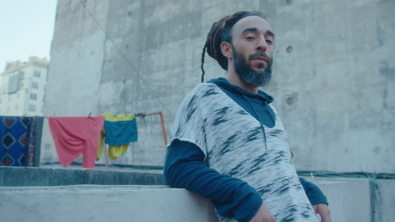 Portrait of Handsome Man With Dreadlocks and Beard on Urban Rooftop