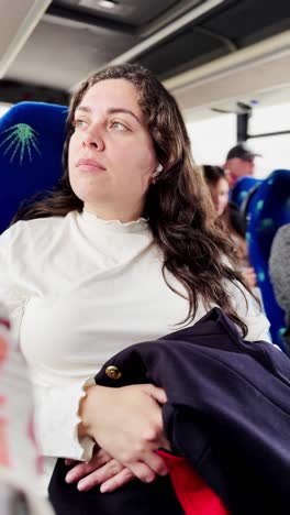 a woman wearing a white shirt is sitting on a bus