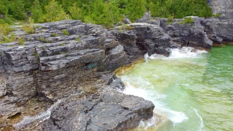 aerial of rugged waves crashing into rugged cliffs of georgian bay