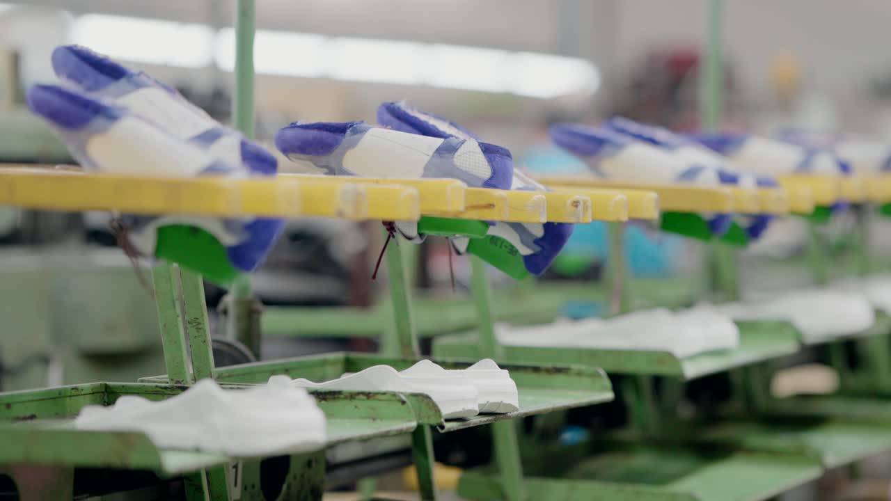 Shoes placed on carts moving along a production line in a shoe manufacturing factory