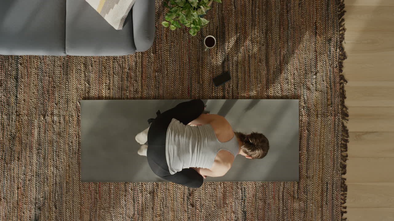 vista dall'alto donna yoga che pratica la posa del corvo esercitando un allenamento di stile di vita sano a casa sul tappetino godendo della meditazione consapevole