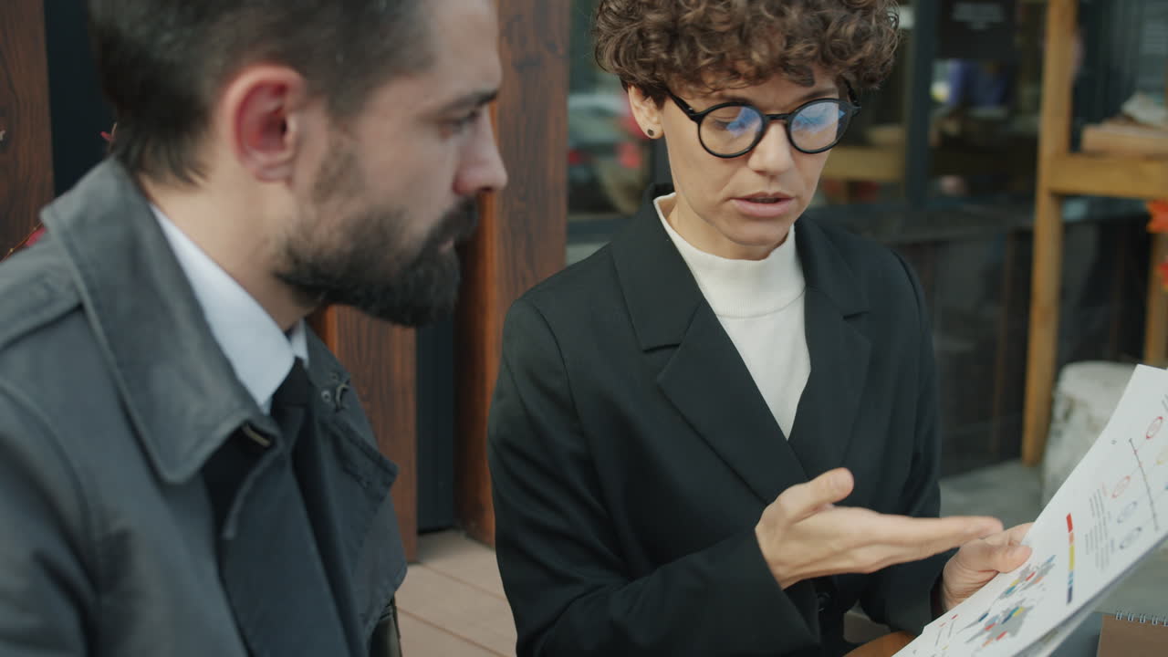 Business People Discussing Graphs Outdoors