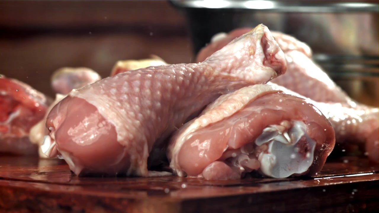 Lavaggio di fusi di pollo crudi con acqua al rallentatore