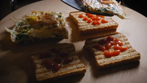 Putting-fried-egg-with-other-ingridients-on-toasted-toast-close-up