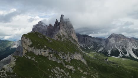 seceda mountains in the italian dolomites with the clouds covering the steep pinnacle shaped cliffs