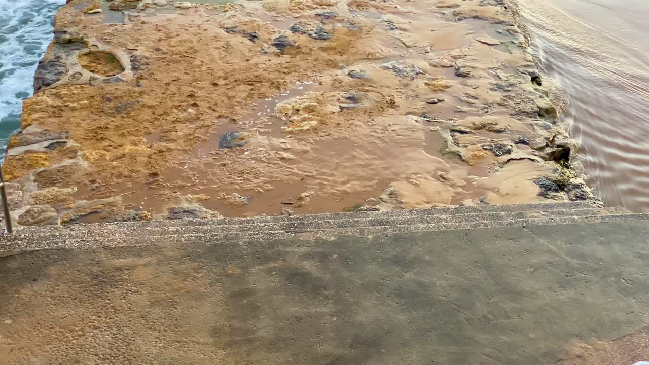 closeup of entrance to the ocean pontoon at Cascais beach with some waves crashing