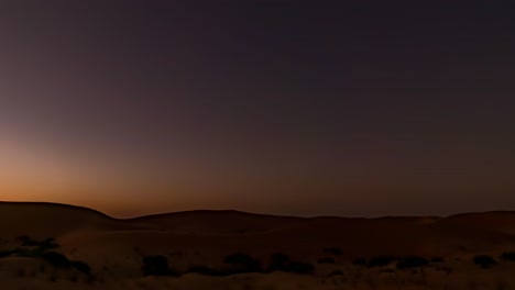 transition time lapse from sunset to starry night over sand dunes in a golden desert landscape