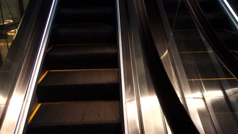 long empty escalator inside building, moving staircase