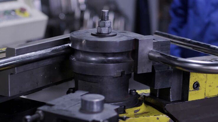 Macchina piegatrice industriale per la piegatura di tubi metallici in fabbrica. Macchina automatica per la lavorazione dei metalli per la tornitura elettronica di tubi metallici e la piegatura a freddo in un capannone industriale presso un impianto di produzione.