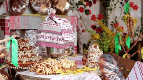 russian samovar is decorated with a belarusian folk doll. table with rolls, baranki, bun, bread and pie. traditional russian tea drinking