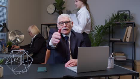 amigable hombre de negocios senior extendiendo la mano a la cámara, ofreciendo un apretón de mano, saludando con una sonrisa