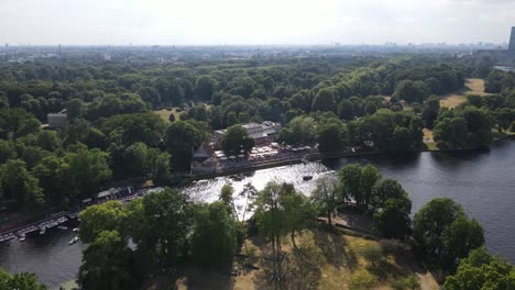 Erleben-Sie-Den-Zauber-Des-Sommers-In-Berlin-Mit-Atemberaubenden-Drohnenaufnahmen-über-Der-Spree,-Die-Ihnen-Einen-Atemberaubenden-Blick-Auf-üppige-Parks,-Belebte-Uferpromenaden-Und-Gelegentliche-Bootsfahrten-Bieten