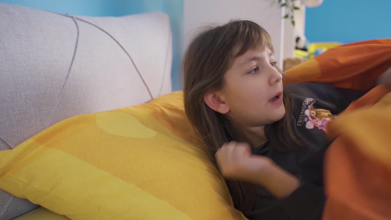 나쁜 악몽을 꾸고 있는 어린 소녀는 갑자기 두려움으로 침대에서 깨어납니다.