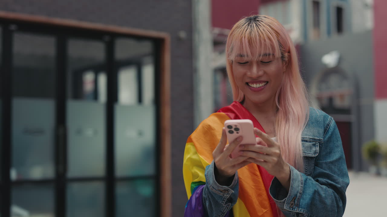 Smiling Person Using Phone with Pride Flag