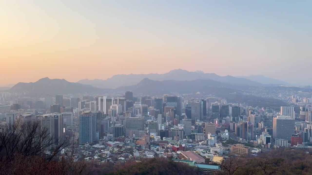 Vista panoramica del tramonto su Seoul con luci urbane e uno skyline sfocato