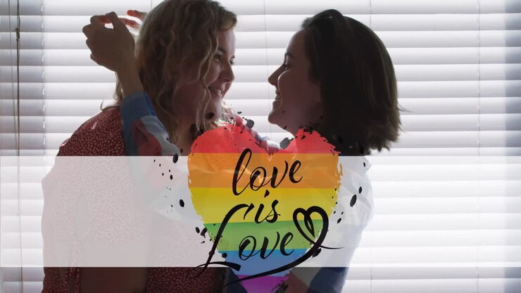 Animation of rainbow heart and love is love over lesbian couple embracing at home