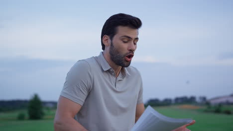 un hombre irritado lanza documentos al club de campo. el golfista sale afuera.