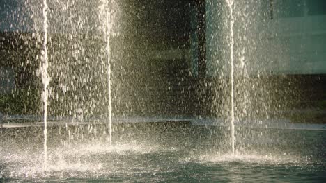 Wassertropfen-Textur-Von-Springbrunnen,-Die-Tröpfchen-über-Die-Teichoberfläche-Verteilen