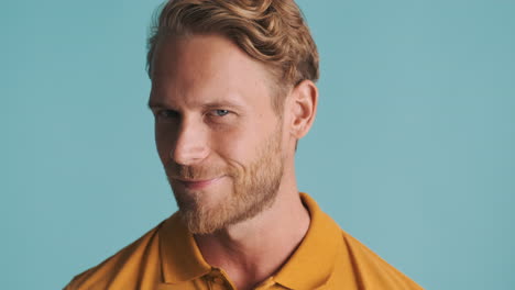 young bearded man looking up, smiling and posing