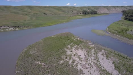 sigue el lento río a través de un valle verde en las praderas.