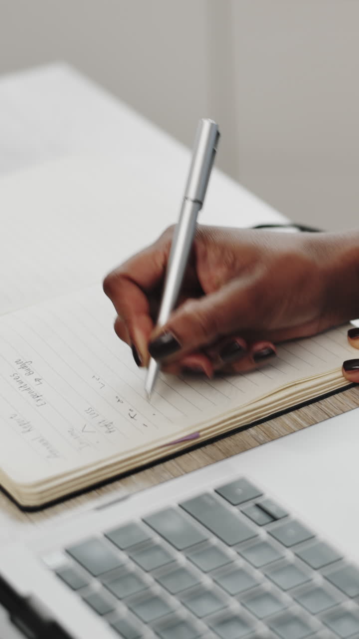 Close-Up of a Person's Hand Writing in a Notebook