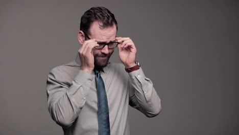 nervous man in dress shirt and tie awkwardly looks around and adjusts glasses