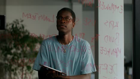 man reviewing notes on glass wall during a meeting