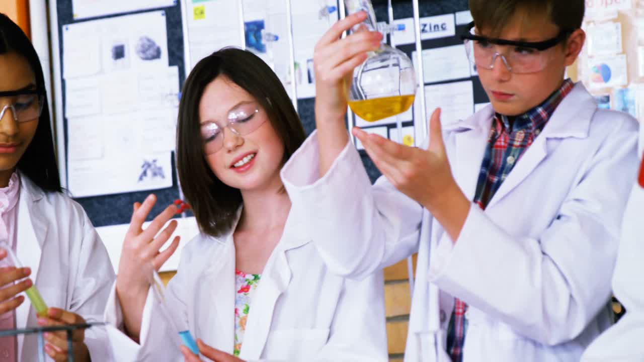 주의 깊은 학교 아이들이 실험실에서 화학 실험을 하고 있습니다.
