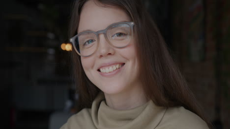 smiling woman wearing glasses in a cafe
