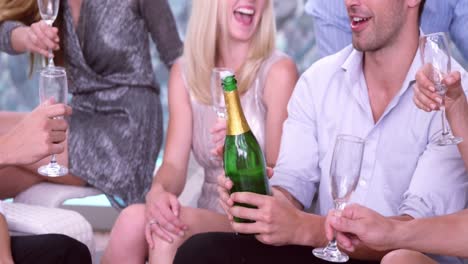 Mann-öffnet-Und-Serviert-Freunden-Champagner