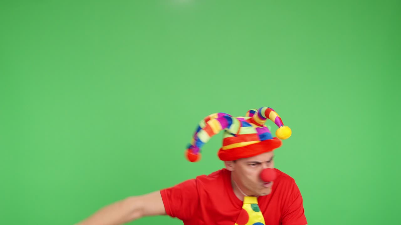 Clown showing different expressions and pointing on green screen