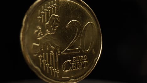 close-up of a 20 euro cent coin with a black background that is spinning