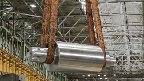 large metal cylinder being transported in a factory