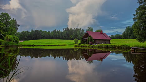 amazing cloudscape above a cabin by a picturesque lake - day-to-night time lapse