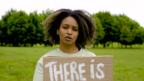 close up of an woman holding a placard and talking