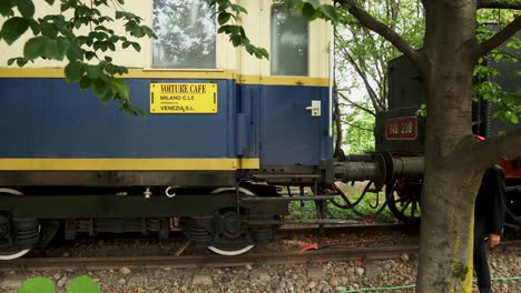 el controlador ferroviario cruza la escena dos veces con el viejo tren de vapor en segundo plano.