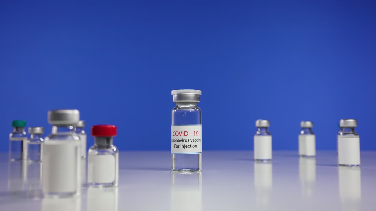 vacunas contra el coronavirus viales retrocediendo y acercándose. vacunación, inmunización, tratamiento para curar la infección por el virus de la corona covid-19. concepto médico. primer plano. cámara lenta