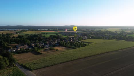 vistas aéreas de globos aerostáticos que vuelan durante el amanecer de la mañana sobre el campo rural en los países bajos