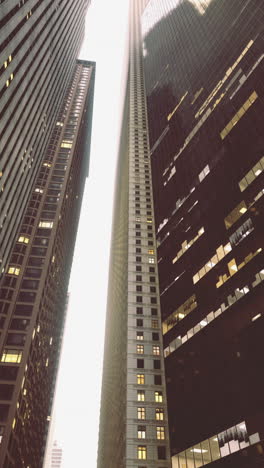 urban canyon formed by tall buildings under cloudy sky at dusk