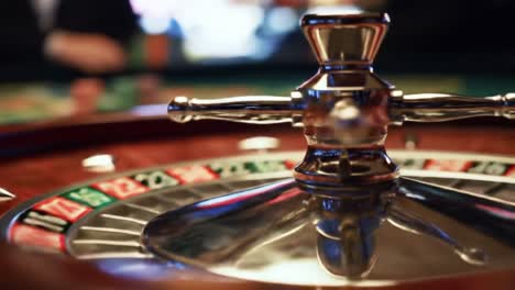 An Exquisite Close-Up View of a Roulette Wheel, Capturing the Moment Before the Spin in a Vibrant Casino Environment with Flickering Lights and Exciting Atmosphere
