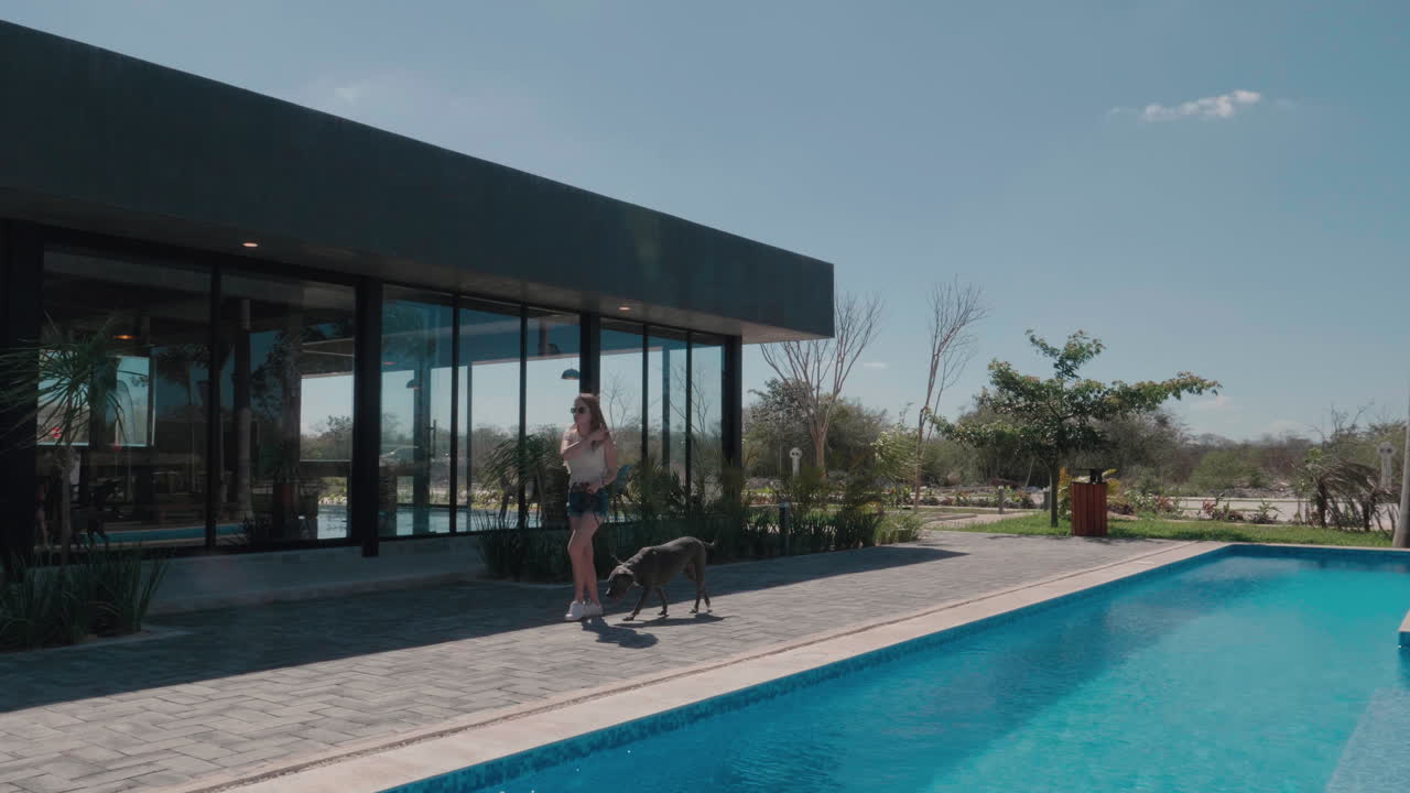 Young Woman walking her dog at a pet friendly modern resort, Slow Motion