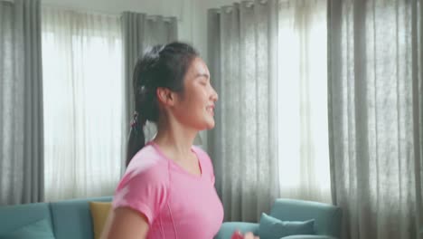 side view of asian woman running on a treadmill at home