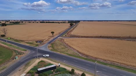 Un-Cruce-De-Caminos-Con-Campos-De-Trigo-Que-Se-Extienden-Hasta-El-Horizonte-En-Victoria,-Australia