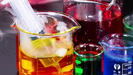 a scientist uses a syringe to mix vibrant liquids in a petri dish, showcasing a chemical reaction.
